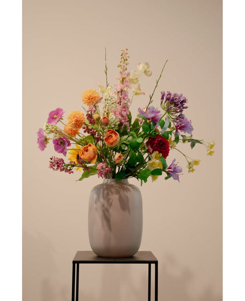 Le Cornouiller Artificiel Real Touch Jaune Clair 74 cm, une fleur artificielle jaune clair réaliste, se dresse dans un vase en céramique avec un feuillage vert sur un support en métal noir sur un fond beige uni.