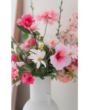 La fleur artificielle Margriet 60 cm blanc/rose, un vase blanc avec des marguerites artificielles roses et blanches, se dresse sur un fond clair et neutre.