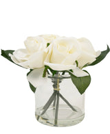 Le Bouquet de Roses Artificielles Real Touch Blanc 18 cm est un petit vase en verre avec plusieurs roses artificielles blanches et feuilles vertes, joliment disposées sur un fond blanc uni.
