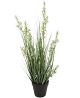 Le gazon artificiel millet oignon en pot 65 cm ignifuge présente des feuilles hautes et fines ressemblant à de l'herbe verte et plusieurs tiges avec de petites fleurs blanches dans un pot noir, sur un fond blanc uni.