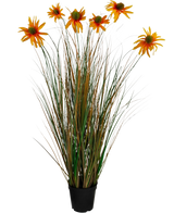 Le pot d'oignon de chrysanthème de gazon artificiel de 90 cm ignifuge a de hautes feuilles vertes et brunes ressemblant à de l'herbe avec sept fleurs de marguerites artificielles orange dans un pot noir, sur un fond blanc.