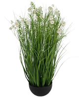 Le pot d'herbe d'oignon de fleur de Gesang blanc de gazon artificiel est une plante artificielle ignifuge de 90 cm avec de longues et fines feuilles vertes et de délicates fleurs blanches dans un pot rond noir, sur un fond blanc uni.