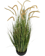 La branche de gazon artificiel Dogtail oignon 110 cm ignifuge est une plante de gazon artificiel en pot avec de longues feuilles vertes étroites et de hautes têtes de graines beiges moelleuses, représentées sur un fond blanc uni.