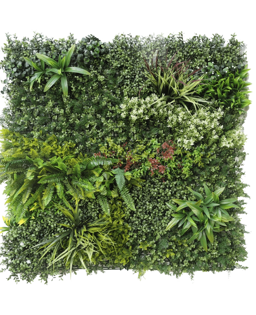 La Haie Artificielle Prestige 100x100 cm UV est un panneau carré de feuillage vert artificiel avec un mélange de plantes feuillues, de fougères, de textures et nuances de vert variées, ainsi que des grappes de petites fleurs blanches et rouges. Le fond est blanc.