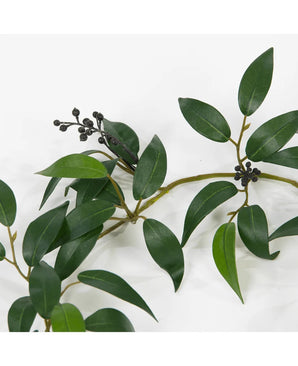 Une guirlande artificielle Smilax de 180 cm avec des feuilles vertes longues et étroites et de petites grappes de baies rondes et sombres, représentées sur un fond blanc.