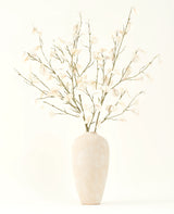 Le bouquet de fleurs artificielles en soie crème d'eucalyptus dans un grand vase en céramique beige clair avec des feuilles blanches transparentes crée une atmosphère sereine dans tout intérieur de fleurs artificielles sur un fond clair.