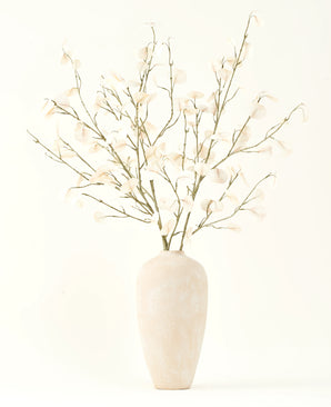 Le bouquet de fleurs artificielles en soie crème d'eucalyptus dans un grand vase en céramique beige clair avec des feuilles blanches transparentes crée une atmosphère sereine dans tout intérieur de fleurs artificielles sur un fond clair.