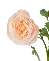 Un gros plan de la rose artificielle "Emine" Real Touch Peach 62 cm, avec des pétales superposés de couleur pêche et des feuilles vertes sur fond blanc.