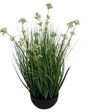 Le gazon artificiel poireau fleur oignon herbe pot 60 cm ignifuge a de hautes et fines feuilles vertes ressemblant à de l'herbe avec de petites grappes de fleurs blanches dans un pot noir, sur un fond blanc.