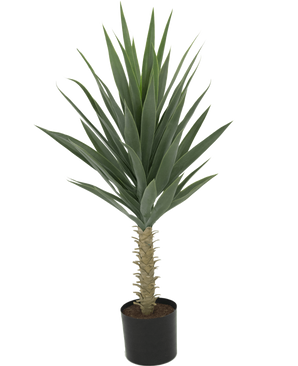 La Plante Yucca Artificielle 100 cm UV est un grand yucca artificiel avec de longues feuilles vertes pointues et un tronc épais, sur un fond blanc uni.